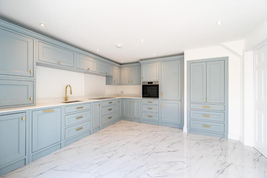 Complete pale-blue shaker kitchen with brass handles