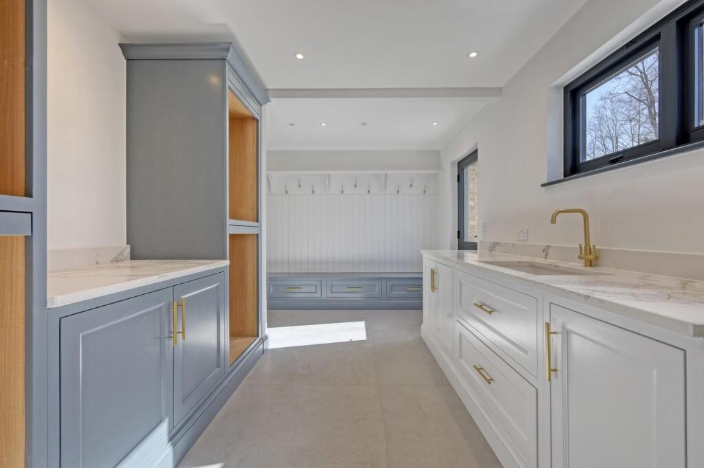 Painted boot-room cabinetry with bench, drawers and coat storage